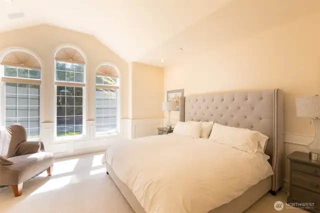 The primary bedroom suite on the main level; light-filled and private from the other parts of the home.