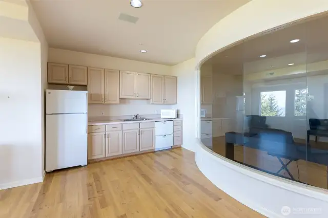 The downstairs area with kitchenette and lovely arc shape of the music room