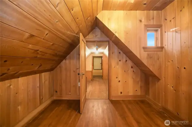 Cedar finished attic space leads through to more finished attic space and a laundry chute!  This home has an incredible amount of storage all around. This adorable room sparks imaginations!