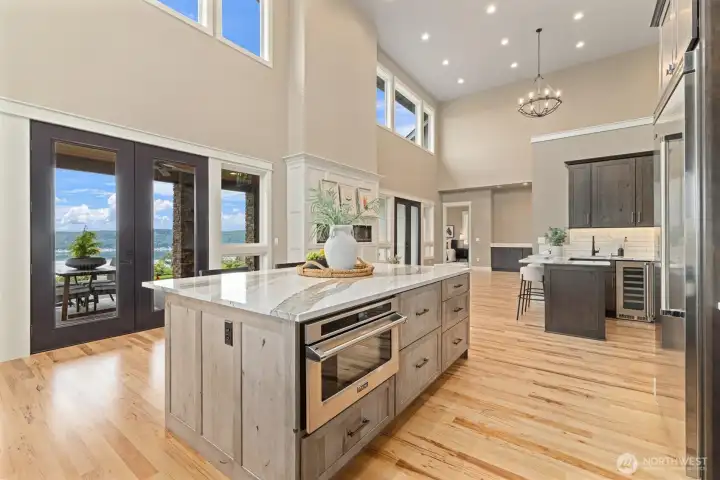 Open Kitchen & Living Space w/ Electric Fireplace. Cambria Skara Brea Kitchen Countertops, Viking appliances, custom soft-close cabinets & drawers w/ inserts & under cabinet lighting.