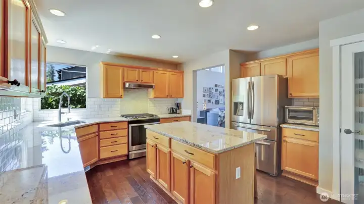 Beautifully designed kitchen featuring ample cabinetry for storage and a bright corner sink framed by large windows.