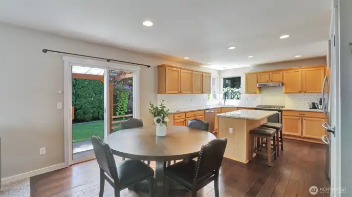 This home offers a bright kitchen and dining area featuring warm cabinetry and flooring, and seamless access to the backyard for easy indoor-outdoor living.