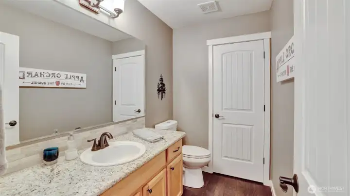 Convenient main level half bath with stylish finishes and ample storage.