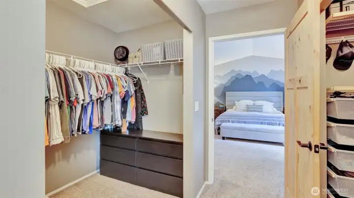 Enjoy this double-sided walk-in closet offering ample hanging space and built-in storage solutions.