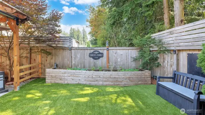 Charming backyard with lush turf and a dedicated garden space, perfect for planting and enjoying the outdoors.