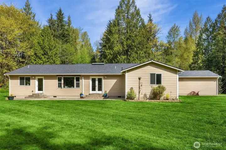 Step outside to your own private retreat with mature fruit trees, curated berry gardens, a fenced vegetable garden, chicken coop, and trails leading to the year-round Little Pilchuck salmon creek. Enjoy evenings around two creekside fire pits while surrounded by peaceful natural beauty. Additional highlights include an artisan well, generator, 2-car garage, and four covered parking spaces.