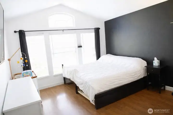 Primary bedroom with vaulted ceilings and large windows