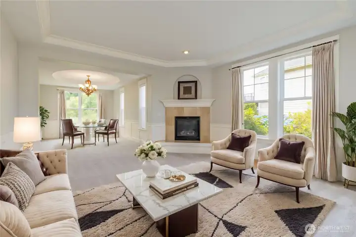 Formal living and dining areas featuring elegant wainscoting and a cozy, sophisticated gas fireplace.