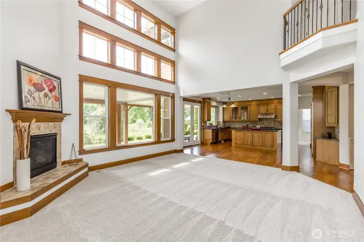 Captivating view of the expansive, two-story family room, showcasing the overlook from the upper-level landing.