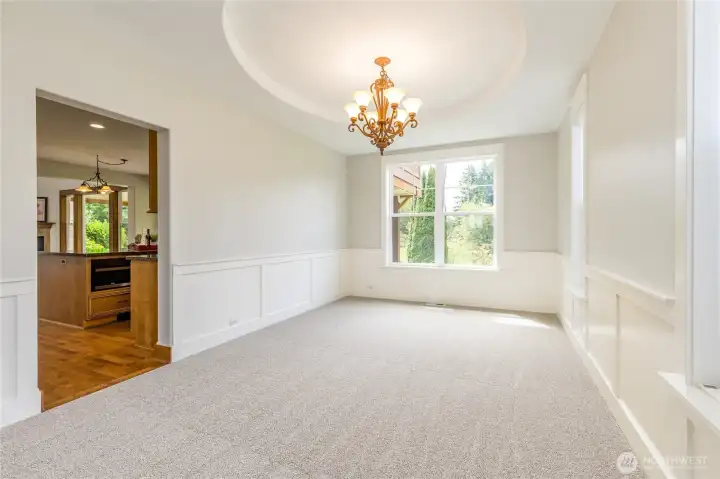 Elegant formal dining room perfectly positioned just off the kitchen, featuring a circular recessed ceiling that adds a sophisticated touch to the space.
