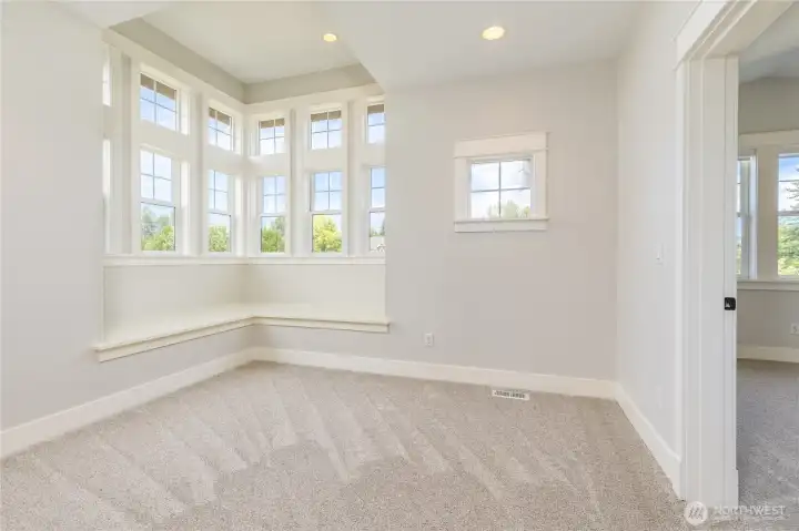 Versatile upstairs alcove with expansive window seating; an ideal flex space that could serve as a cozy reading nook, homework station, or play area.