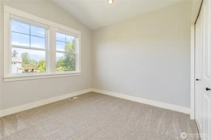 Bright and inviting third bedroom featuring a beautiful vaulted ceiling.