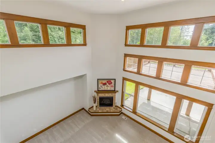 Stunning overlook view from the upper level, highlighting the open-concept floor plan and connection to the soaring, two-story family room below.
