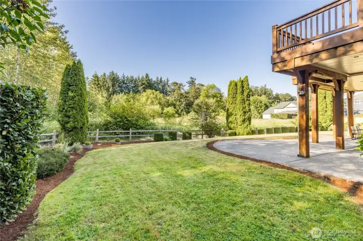 Enjoy a peaceful retreat in your own backyard, featuring a beautifully manicured, level lawn that backs up to a protected natural space, ensuring excellent privacy and serene views.