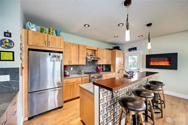 The kitchen has custom cabinets, gorgeous counters and a new wall-mounted propane fireplace -- adds great atmosphere on a chilly morning or for an evening dinner party.