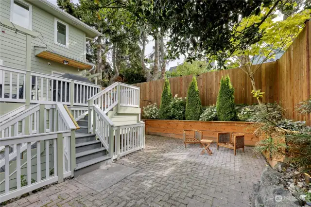 Off the deck is a sweet sheltered and private brick patio.