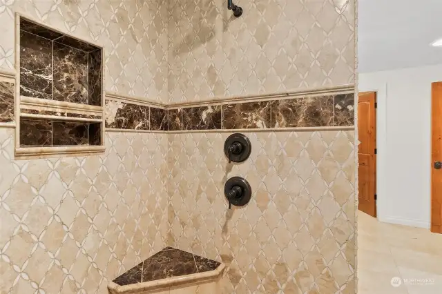 Beautiful tiled walk in shower with bench and recessed shelf.