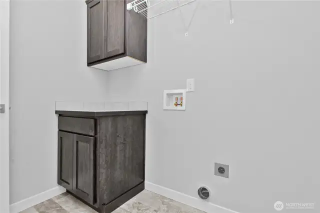 Laundry room is on main floor and includes storage cabinets and shelving.