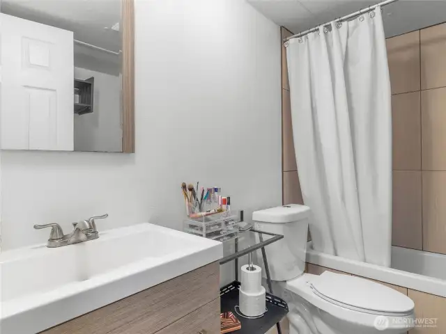 Full bathroom with tile shower and modern vanity.