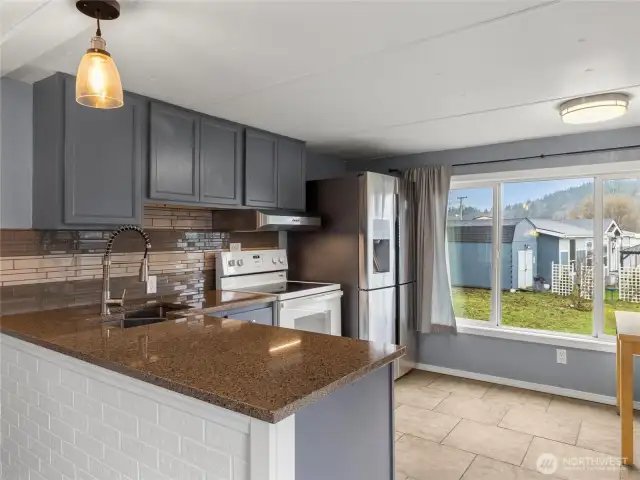 Updated kitchen with tile backsplash, newer stainless steele appliances and updated cabinets.