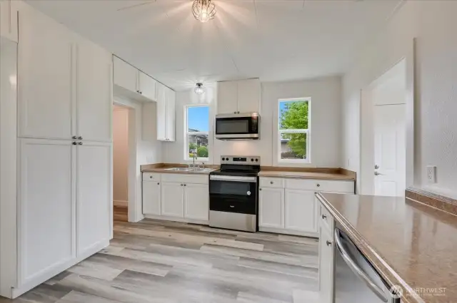 Open kitchen with entrance to the walk in pantry and large cabinets for extra storage