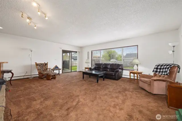Main House:  Spacious living room with wood-burning fireplace & wet bar with beautiful picture windows offering lots of natural light.  Entry point to the outdoor living space via a sliding glass door.