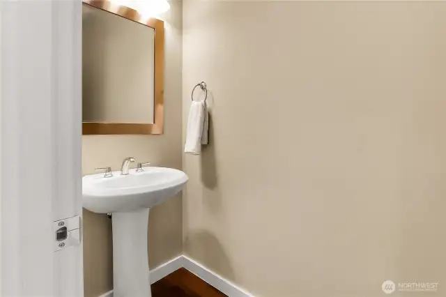 A half bath is centrally located on the main level and features Kentwood timber flooring and a pedestal sink.