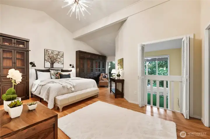 This generous primary bedroom draws you in with its interesting lines and vaulted ceilings, and invites you to stay with its large windows and doors that open to below.