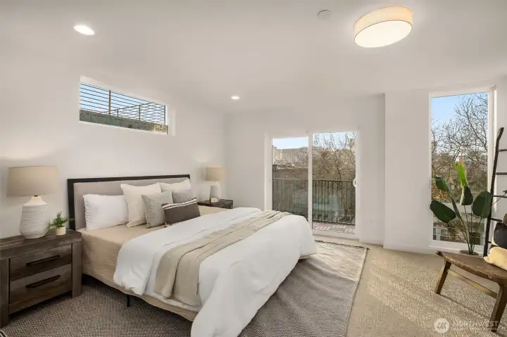 Airy primary bedroom with massive floor to ceiling windows creating an open light hearted energy. With a sliding glass door to give you a breath of fresh air turning this bedroom into a true retreat