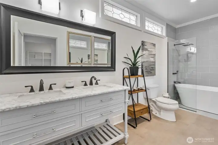 Newly refreshed luxury bathroom featuring a double vanity, soaking tub, and shower.