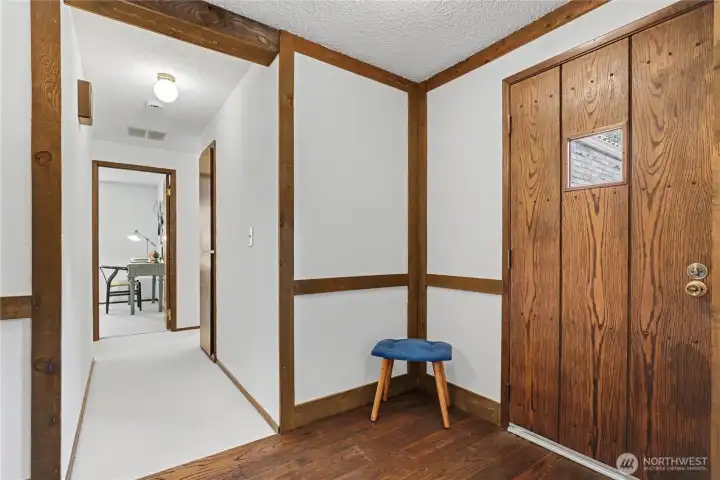 Clean entry hall with wood trim accents, natural light, and access to multiple main-level living spaces.