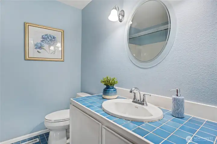 Bright bathroom with blue tile accents, updated fixtures, and a cohesive color palette.