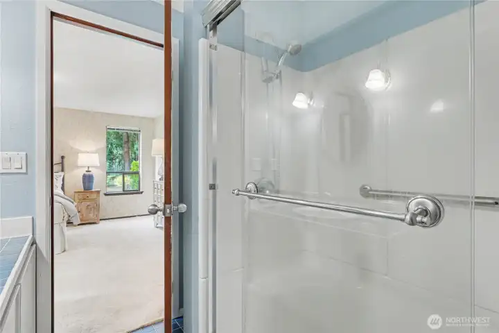 Bathroom with blue accents and a clear view into the adjoining bedroom, showcasing the home’s connected floor plan.
