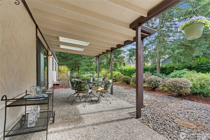 Expansive 25,700-sq-ft lot featuring a large covered patio, mature landscaping, and a private wooded backdrop ideal for outdoor living.