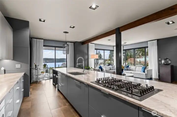 The kitchen features leathered quartzite counters, Bosch appliances, and a host of storage with cabinets and drawers on both sides of the island, as well as a generous pantry.