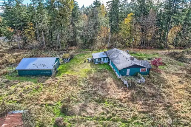 East to West view showing 20X24 barn, paddock, sunroom chicken coop, previous deck.  outbuilding and the level lay of the land for the property.  Treelined gives privacy from neighbors and all the hard clearing done.