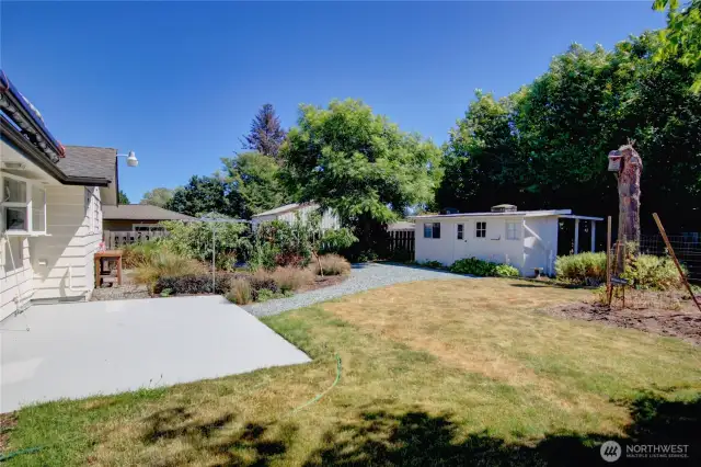 Beautiful private backyard with large garden area, fruit trees, blueberries, outdoor sink, patio with an awning above.
