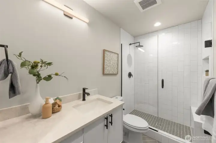 Primary suite carries luxury finishes, including rainfall shower head, 3cm quartz countertops, full tile surround and glass door entrance (photos are of 1108B, similar floor plans & finishes)