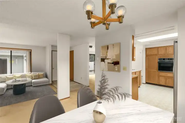 Virtually staged dining room looking into kitchen and sitting room.