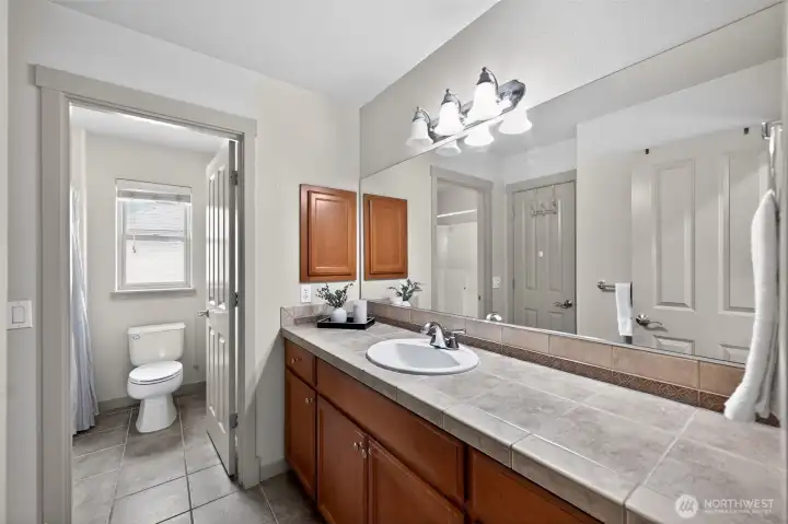 Generously-sized guest bath with dual vanities and a shower/tub combination