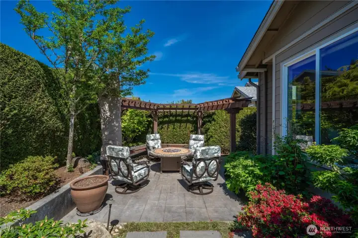 Custom arbors with built-in bench seating flank the firepit nestled in your private sanctuary. The 13' cantilever umbrella set in a concrete base will shade you and your guests from the afternoon sun.