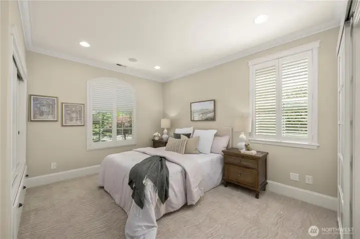 The guest suite with Plantation shutter, a custom closet with three built-in drawers, high-end carpet and pad, and a custom barn door to the private bathroom.