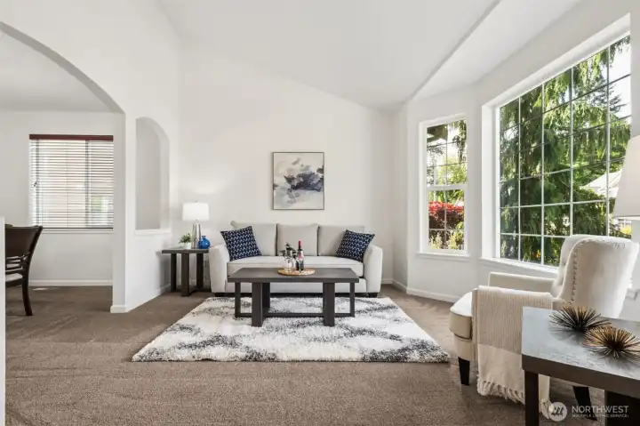 Bright front living room with soaring ceilings, dramatic windows, and beautiful natural light throughout