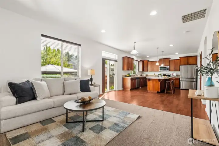 Warm and inviting living room with cozy fireplace, abundant natural light, and elegant neutral finishes    2. **Spacious gathering space featuring gas fireplace, oversized windows, and comfortable everyday living**    3. **Open-concept design seamlessly connects the living room and beautiful entertainer’s kitchen**