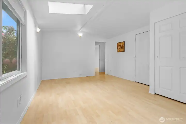 Large primary with skylights and backyard access.