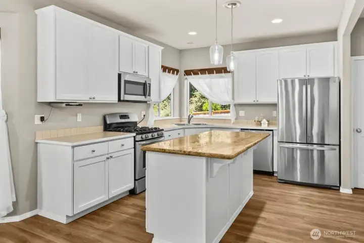 LARGE KITCHEN ISLAND WITH GRANITE COUNTERTOP AND EATING SPACE IS THE HEART OF THE KITCHEN