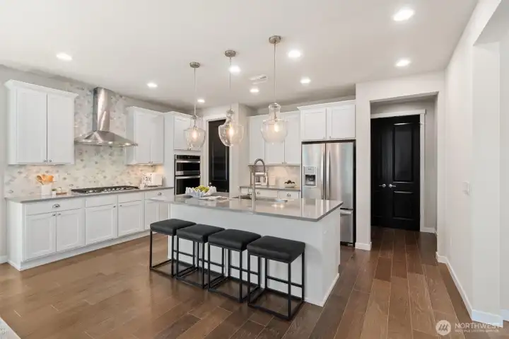 Quartz counters, sculptural tile, pendant lighting, and classic cup pulls create a fresh, tailored look.
