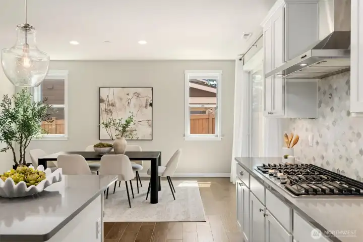 The dining area opens naturally toward the covered backyard patio, extending the heart of the home into a beautifully connected outdoor living space.