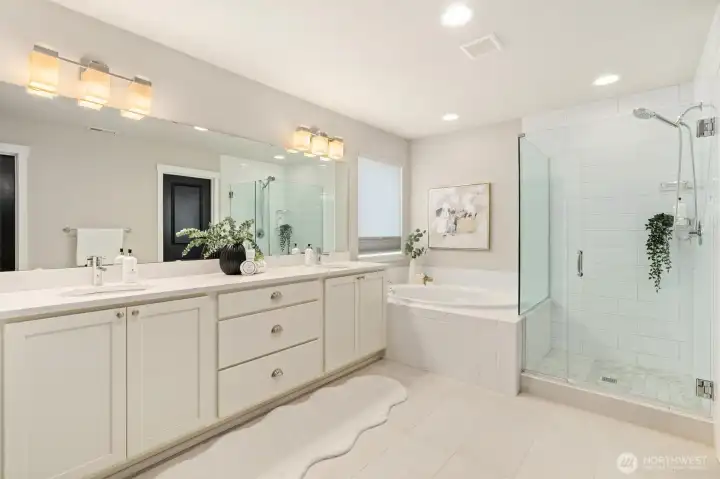 A soaking tub, walk-in tile shower, double vanity, and spacious closets make mornings easier and evenings restorative.