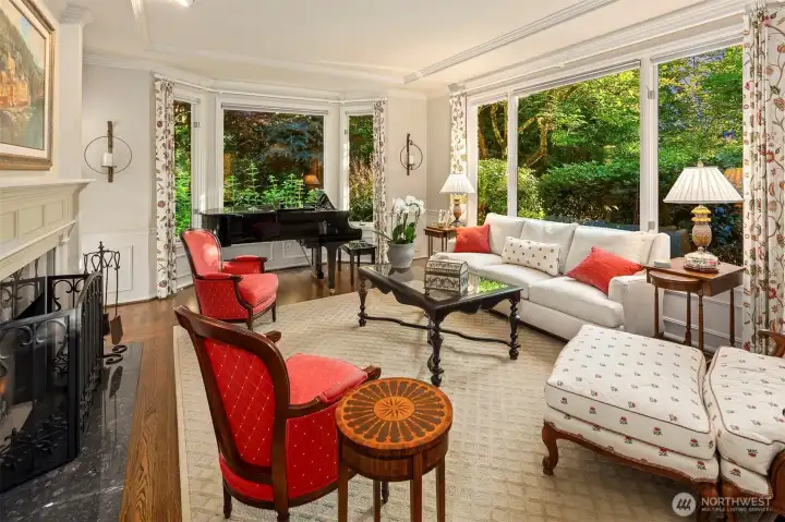Living room with marble fireplace and tray ceiling. Large enough for a grand piano and plenty of seating. Not shown are floor to ceiling lighted alcoves with glass shelves for displaying art, pictures or other treasures.